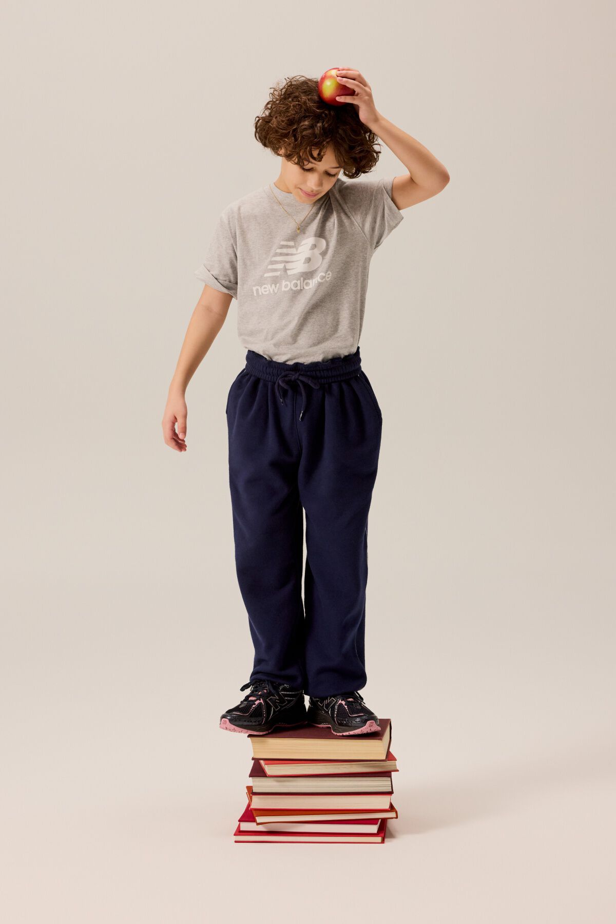Child standing on a pile of books.